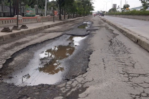 jalan rusak Indonesia dengan lubang besar di jalur utama