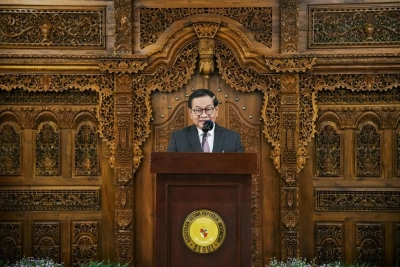 "Pejabat Pemprov DKI Jakarta berbicara di podium dalam acara resmi, dengan latar belakang ukiran kayu tradisional Indonesia di Kedutaan Besar Republik Indonesia di Seoul."