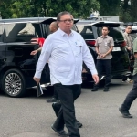 Airlangga Hartarto berjalan menuju rapat terbatas ekonomi di Istana Kepresidenan Jakarta bersama pejabat pemerintah membahas stabilitas dan kebijakan ekonomi nasional.